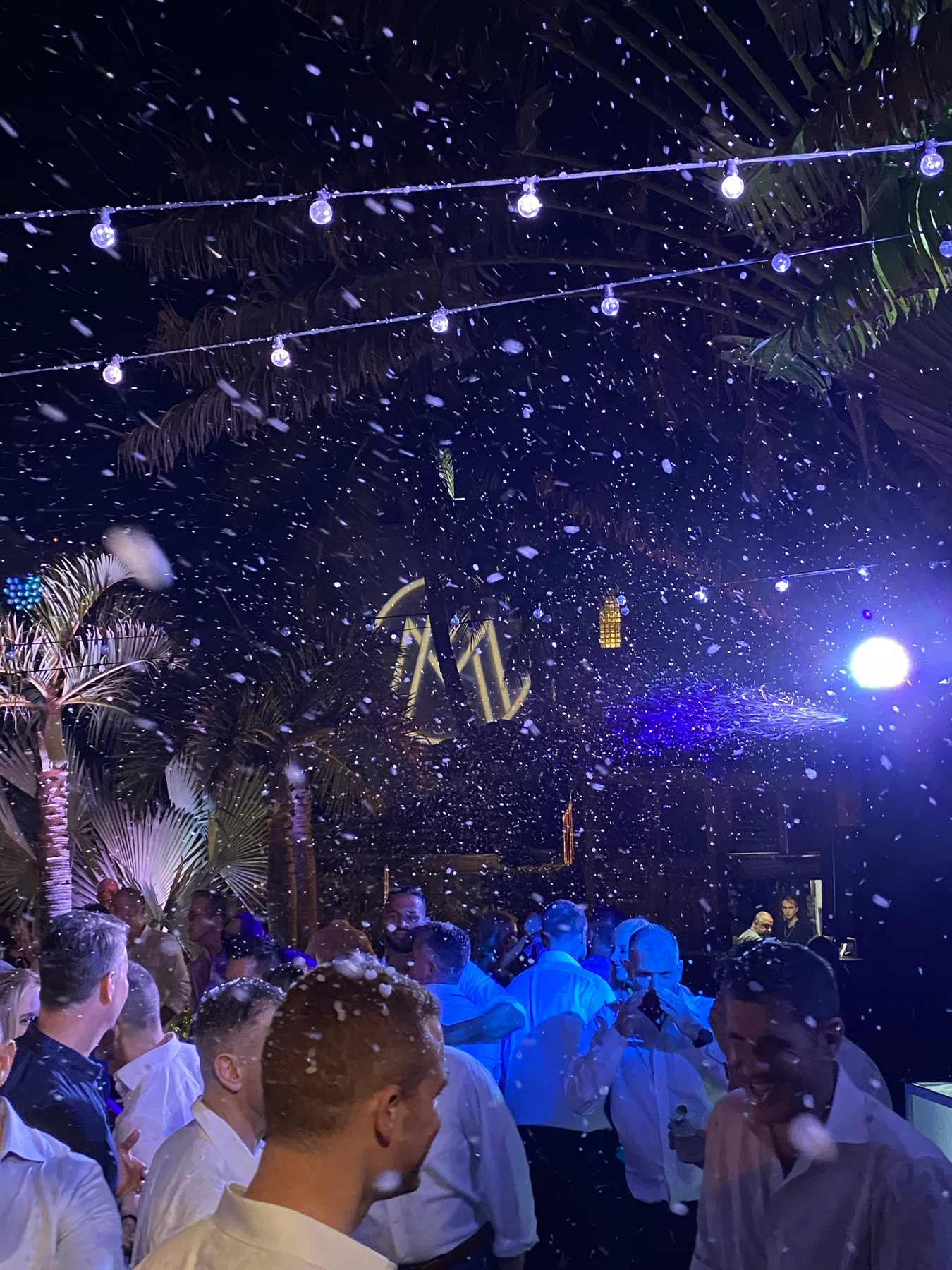 Guests on a dance floor beneath falling confetti