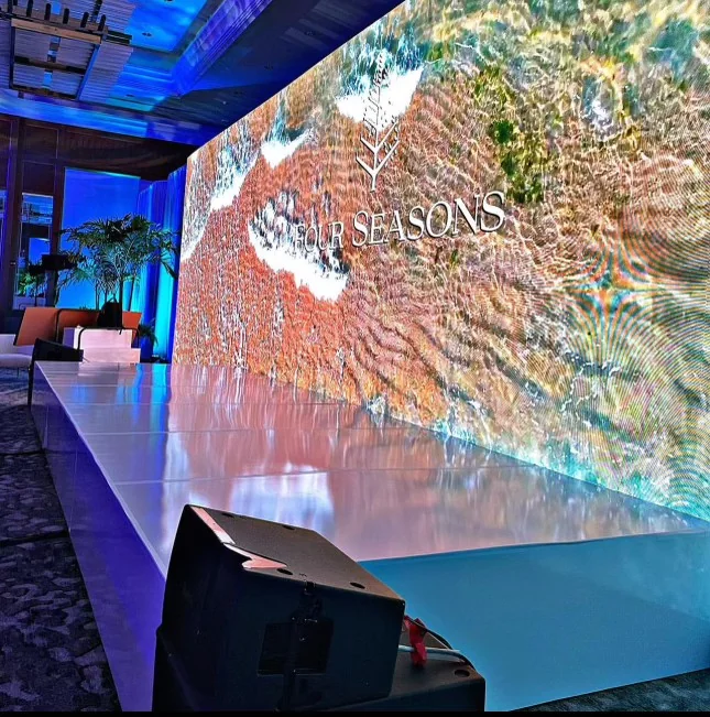 A large LED video wall on a white stage
