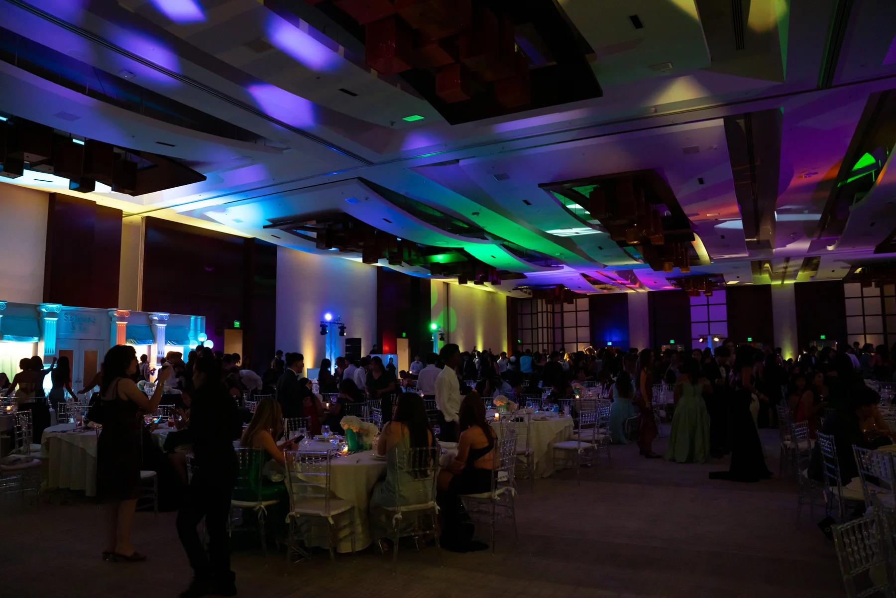 A ballroom lit in blue, green and purple during an event