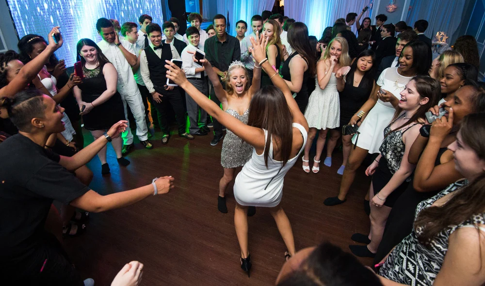Guests dancing together around the DJ and MC
