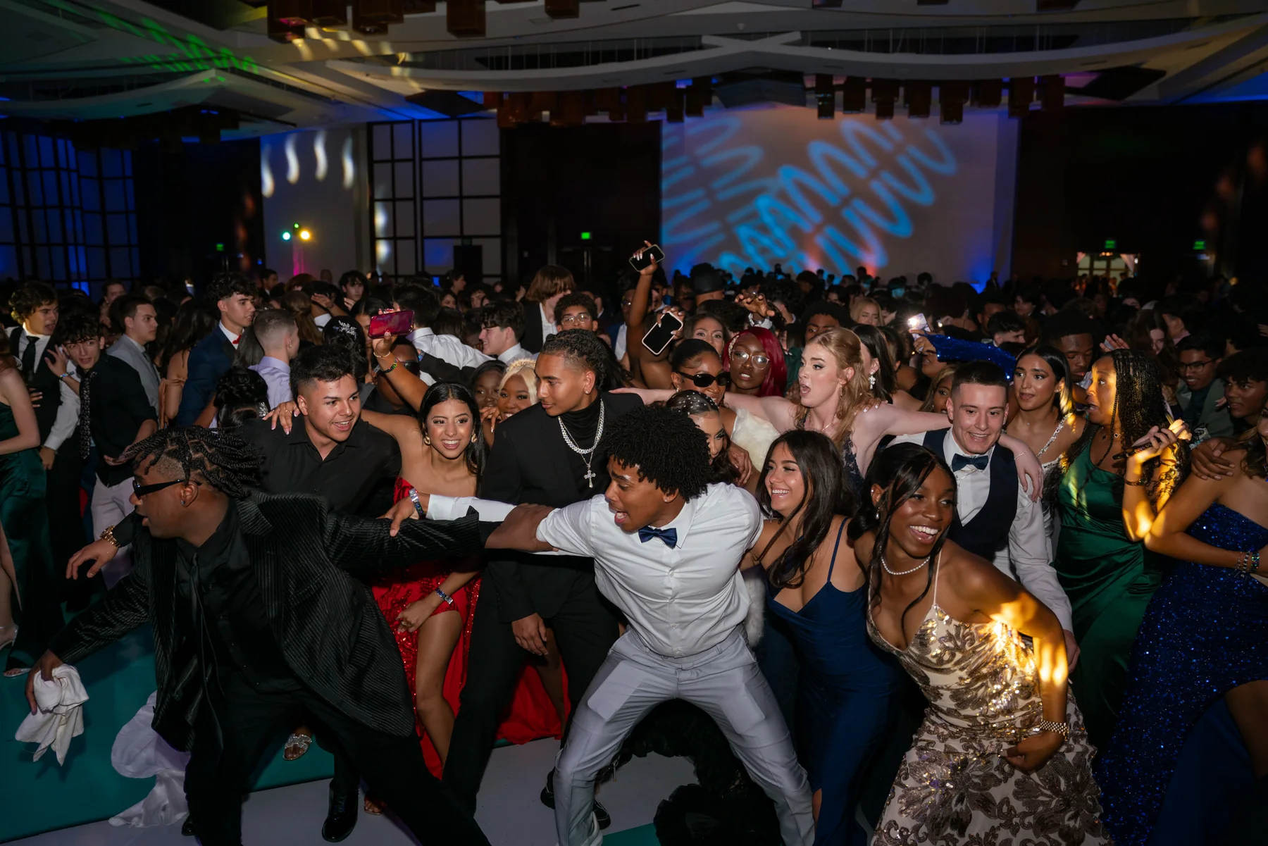 Guests celebrating together on a school-event dance floor